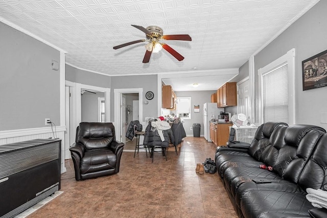 living room featuring ceiling fan and ornamental molding