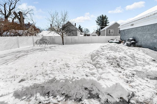 yard covered in snow with a fenced backyard