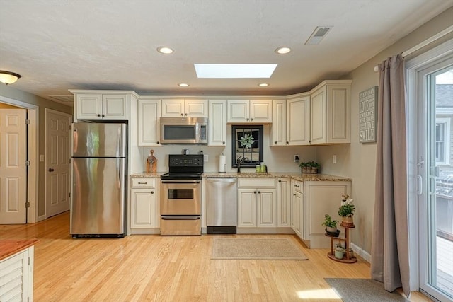 7 Luan Cir, Chelmsford, MA 01824 - kitchen with appliances with stainless steel finishes, a skylight, light wood-type flooring, light stone counters, and recessed lighting