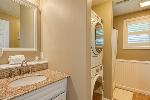 7 Luan Cir, Chelmsford, MA 01824 - full bath with stacked washer / drying machine, vanity, a shower with shower curtain, and a wainscoted wall