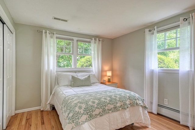 7 Luan Cir, Chelmsford, MA 01824 - bedroom featuring multiple windows, light wood-type flooring, and a baseboard radiator
