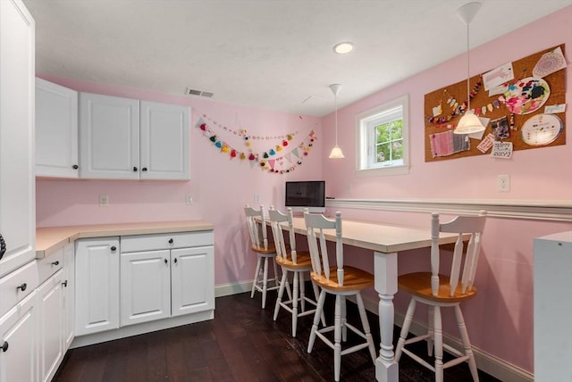 23 Crimson Dr, Shrewsbury, MA 01545 - kitchen with dark wood-type flooring, white cabinetry, light countertops, baseboards, and a kitchen breakfast bar
