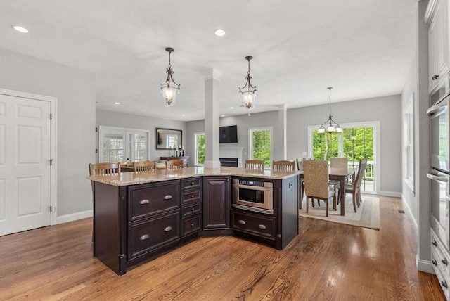 23 Crimson Dr, Shrewsbury, MA 01545 - kitchen with wood finished floors, baseboards, recessed lighting, hanging light fixtures, and light stone countertops