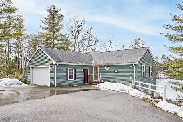 ranch-style house featuring a garage, roof with shingles, driveway, and fence