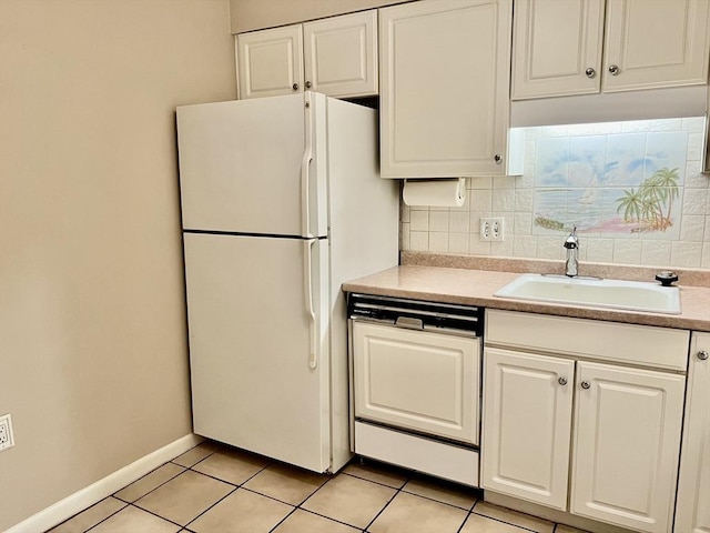 kitchen featuring dishwasher, a sink, freestanding refrigerator, and white cabinets