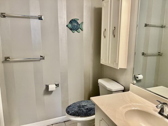 half bath featuring toilet, vanity, tile patterned flooring, and baseboards