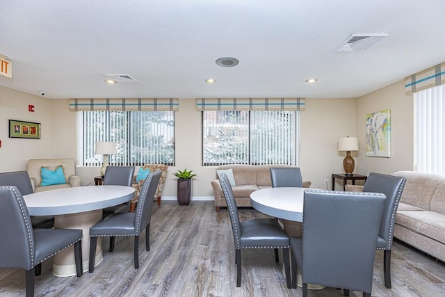 dining area with wood finished floors, healthy amount of natural light, baseboards, and recessed lighting