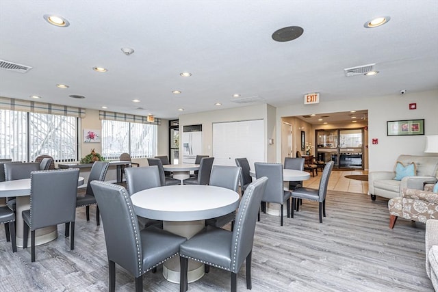 dining space with light wood-style floors and recessed lighting