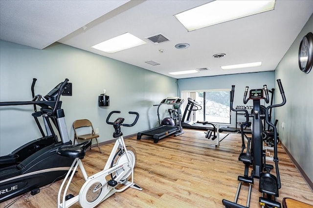 workout area featuring wood finished floors and baseboards