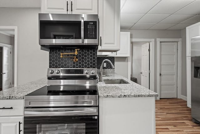 8 Hobson Ave, Worcester, MA 01603 - kitchen with stainless steel appliances, wood finished floors, white cabinetry, and light stone countertops