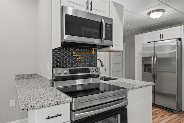8 Hobson Ave, Worcester, MA 01603 - kitchen featuring appliances with stainless steel finishes, white cabinets, light stone countertops, and a drop ceiling