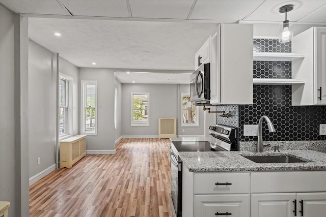 8 Hobson Ave, Worcester, MA 01603 - kitchen with stainless steel appliances, light wood-style floors, open shelves, white cabinetry, and light stone counters
