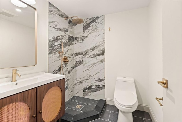 bathroom with a tile shower, toilet, tile patterned floors, and vanity