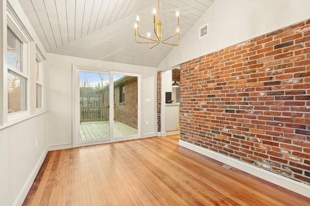 interior space featuring light hardwood / wood-style flooring, vaulted ceiling, wooden ceiling, brick wall, and a chandelier