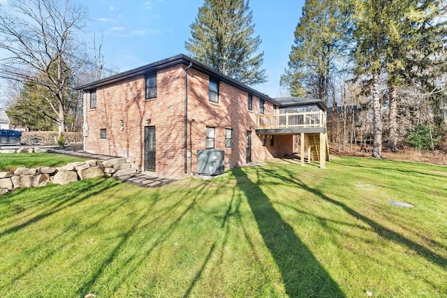 rear view of house with a sunroom, central AC unit, a lawn, and a deck