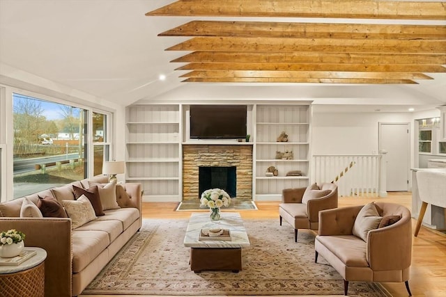 living room featuring vaulted ceiling with beams, a stone fireplace, and light wood-type flooring