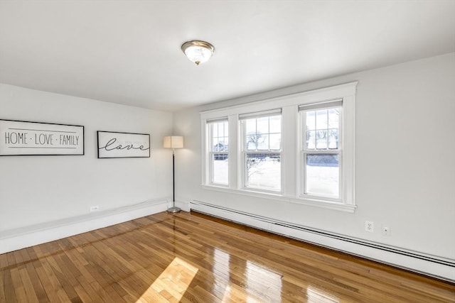 spare room featuring a baseboard radiator and hardwood / wood-style floors