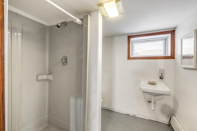 bathroom with a baseboard radiator, sink, concrete floors, and walk in shower