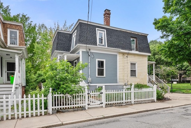 225 Amory St, Boston, MA 02130 - view of front facade featuring a shingled roof, a chimney, a fenced front yard, and mansard roof