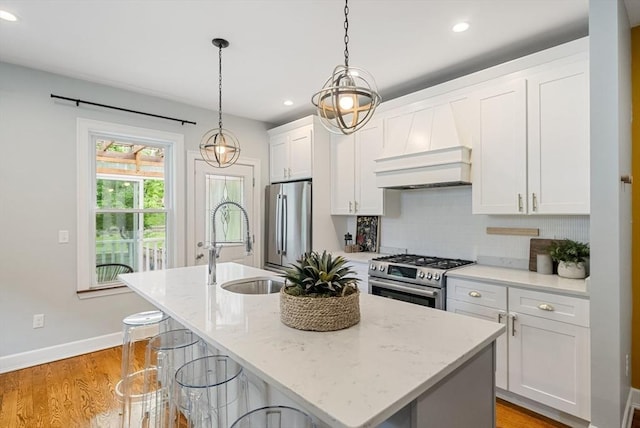 225 Amory St, Boston, MA 02130 - kitchen with appliances with stainless steel finishes, a sink, custom exhaust hood, an island with sink, and recessed lighting
