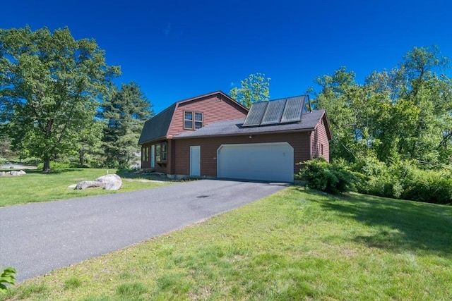 231 Audubon Rd, Northampton, MA 01053 - view of home's exterior featuring a gambrel roof, a yard, a garage, asphalt driveway, and roof mounted solar panels