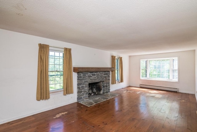 231 Audubon Rd, Northampton, MA 01053 - unfurnished living room featuring a baseboard heating unit, hardwood / wood-style flooring, a fireplace, baseboards, and a textured ceiling