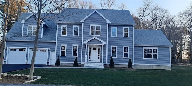 colonial home featuring a front lawn and a garage