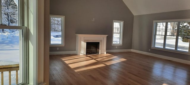 unfurnished living room featuring vaulted ceiling, a fireplace, and dark hardwood / wood-style floors