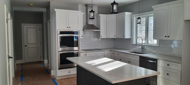 kitchen featuring white cabinetry, decorative light fixtures, a kitchen island, black appliances, and sink