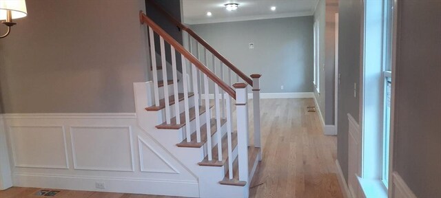 stairway featuring crown molding and wood-type flooring