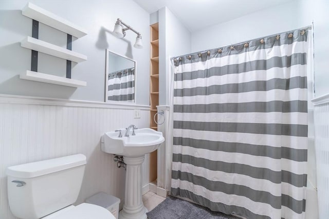 bathroom featuring a shower with curtain, tile patterned floors, toilet, and sink