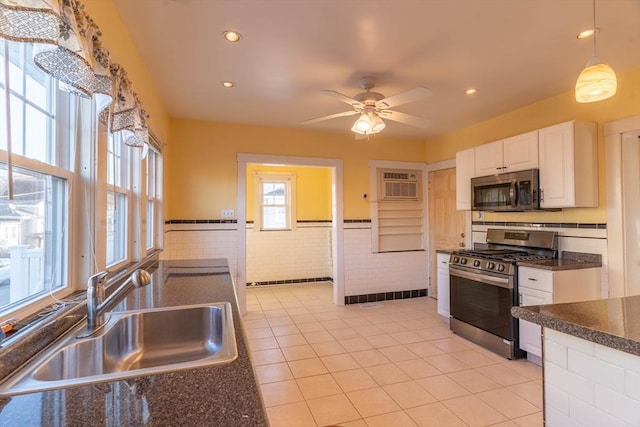 kitchen with sink, hanging light fixtures, stainless steel appliances, white cabinets, and light tile patterned flooring