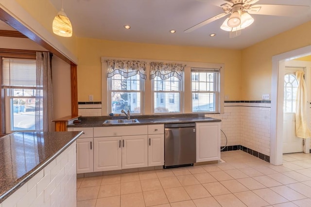 kitchen with sink, light tile patterned floors, dishwasher, white cabinetry, and decorative light fixtures