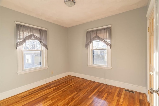 empty room with wood-type flooring and a wealth of natural light