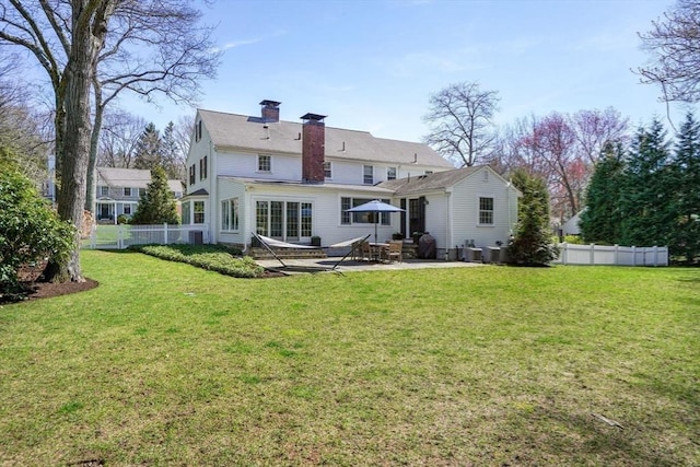 rear view of house with central AC, a swimming pool, a patio, and a lawn