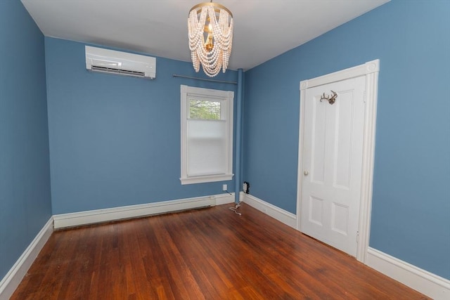 172 Doyle Ave Unit 1, Providence, RI 02906 - empty room featuring an inviting chandelier, baseboards, a wall mounted air conditioner, and wood finished floors