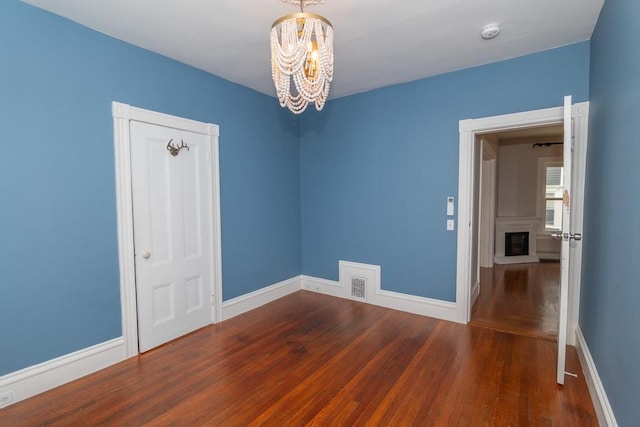 172 Doyle Ave Unit 1, Providence, RI 02906 - unfurnished room featuring baseboards, a chandelier, wood finished floors, and visible vents