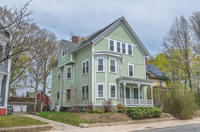 172 Doyle Ave Unit 1, Providence, RI 02906 - view of front of home with covered porch, a chimney, an outbuilding, and central AC