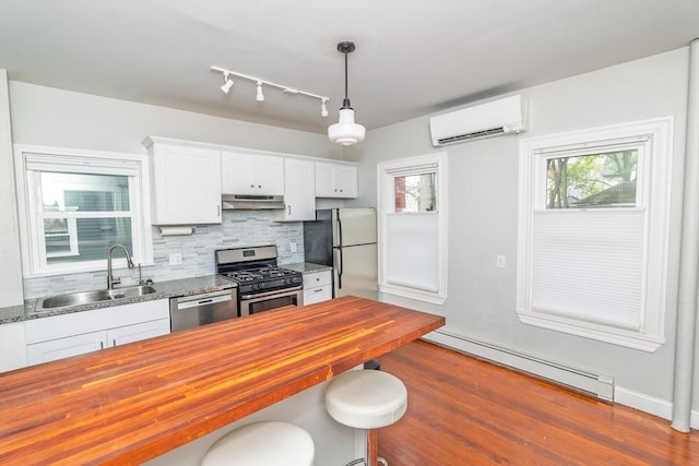 172 Doyle Ave Unit 1, Providence, RI 02906 - kitchen featuring appliances with stainless steel finishes, a sink, wood counters, a baseboard radiator, and under cabinet range hood