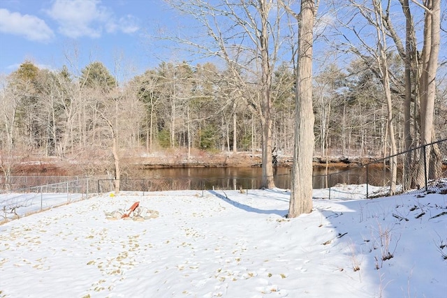 yard layered in snow featuring a water view