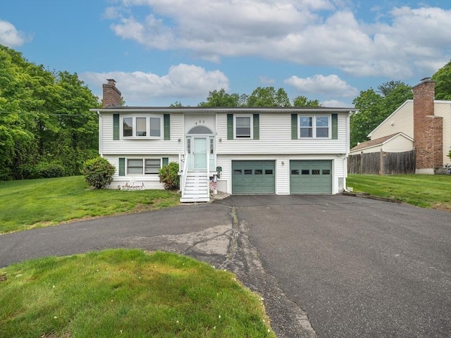 453 Homestead Ave, Holyoke, MA 01040 - bi-level home with driveway, an attached garage, and a chimney