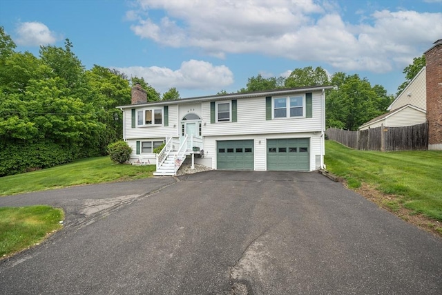 453 Homestead Ave, Holyoke, MA 01040 - split foyer home with a chimney, asphalt driveway, and a garage