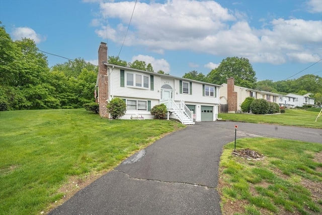 453 Homestead Ave, Holyoke, MA 01040 - bi-level home with a chimney, driveway, an attached garage, and a front lawn