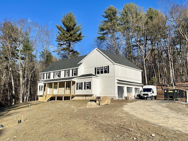 rear view of property featuring a porch and a garage