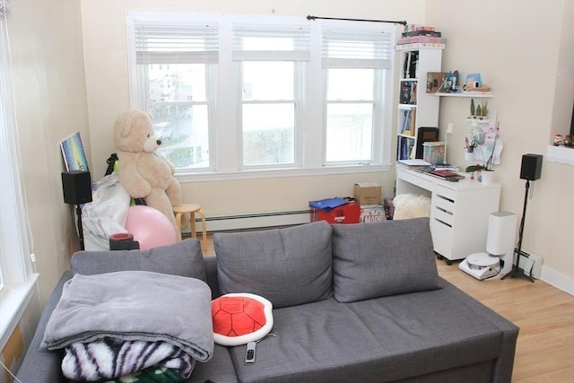 interior space featuring light wood-type flooring, a baseboard heating unit, and baseboards