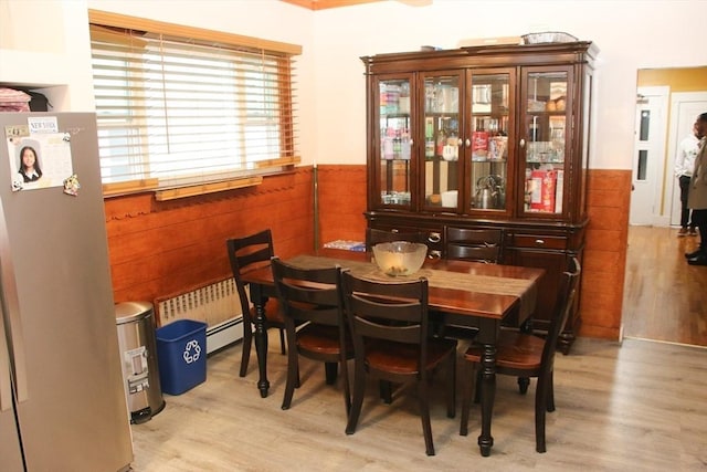 dining room with radiator, a wainscoted wall, and light wood finished floors