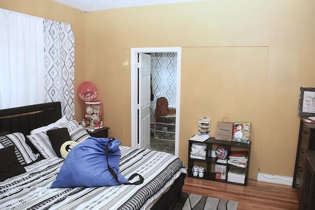bedroom with wood finished floors and baseboards
