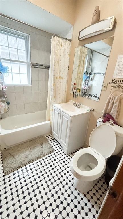 bathroom with shower / bath combo with shower curtain, toilet, tile patterned flooring, and vanity