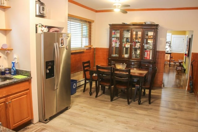 dining room with ornamental molding, ceiling fan, light wood-style flooring, and wainscoting