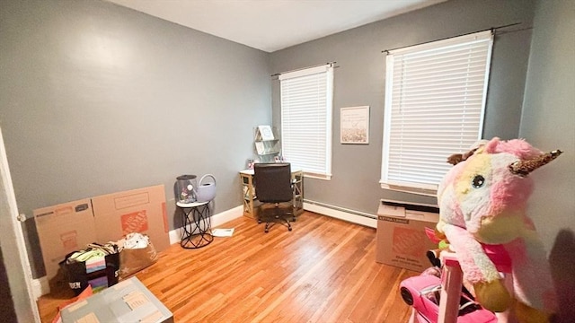 sitting room with light wood-type flooring, baseboards, and a baseboard radiator
